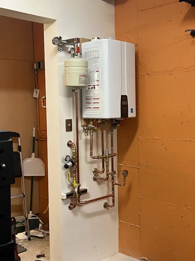Plumbing technician inspecting water heater connections in Fremont